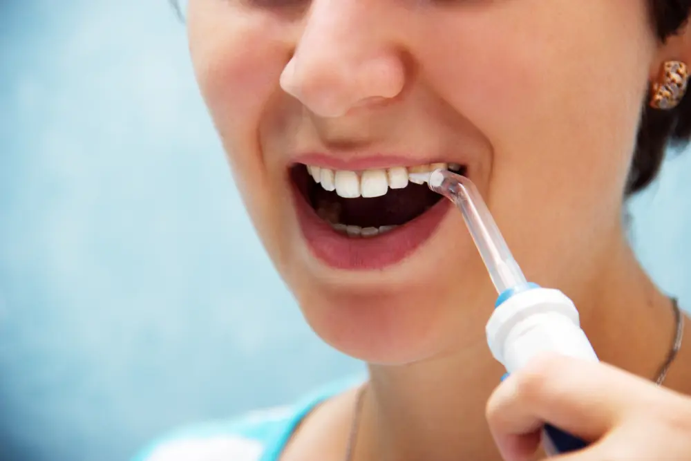woman using water pic on teeth