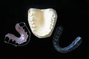 Image URL: https://pixabay.com/photos/orthodontic-aids-mouth-guard-315784/ ALT Text: Dental appliances 