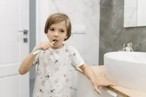 Photo by Pavel Danilyuk: https://www.pexels.com/photo/boy-brushing-his-teeth-8762973/ boy brushing his teeth in a bathroom